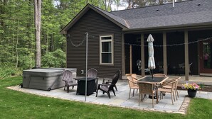 A cabin with a patio area featuring outdoor furniture, a hot tub, and a string of lights. - Naples Valley Getaway-Private home with hot tub.   (Naples)