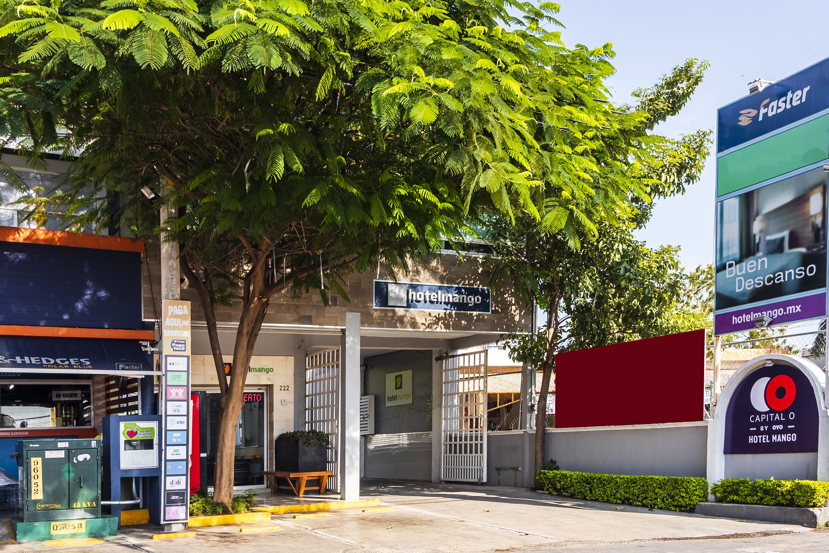 A hotel entrance with a sign for 'Hotel Mango' and a 'Faster' sign nearby.