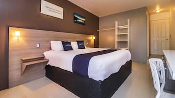 Et moderne hotelværelse med en stor seng, sengeborde, et skrivebord og en stol.