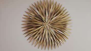 Una pieza decorativa montada en la pared con un diseño radial de elementos metálicos.