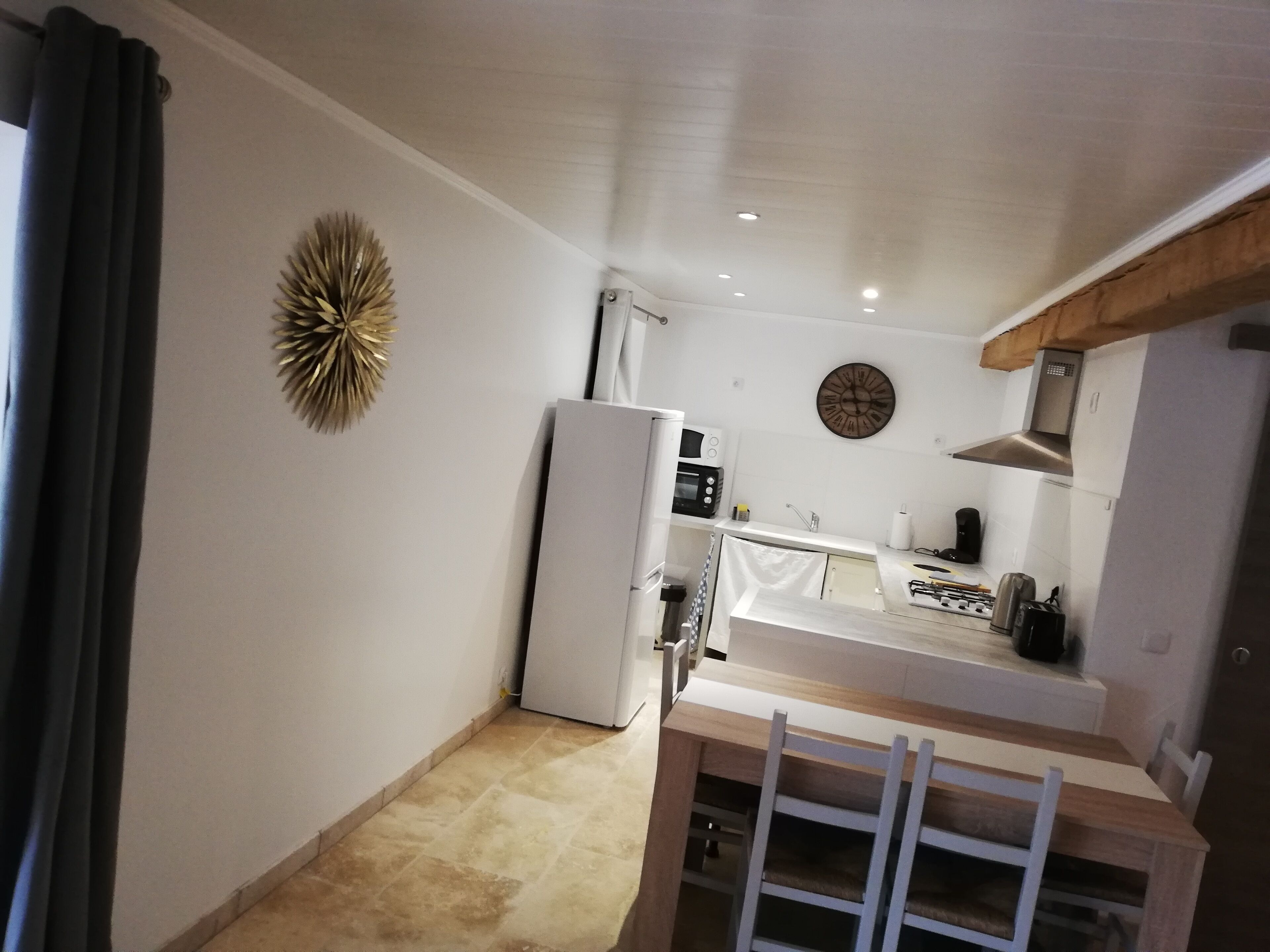Uma cozinha compacta com geladeira, micro-ondas e fogão.