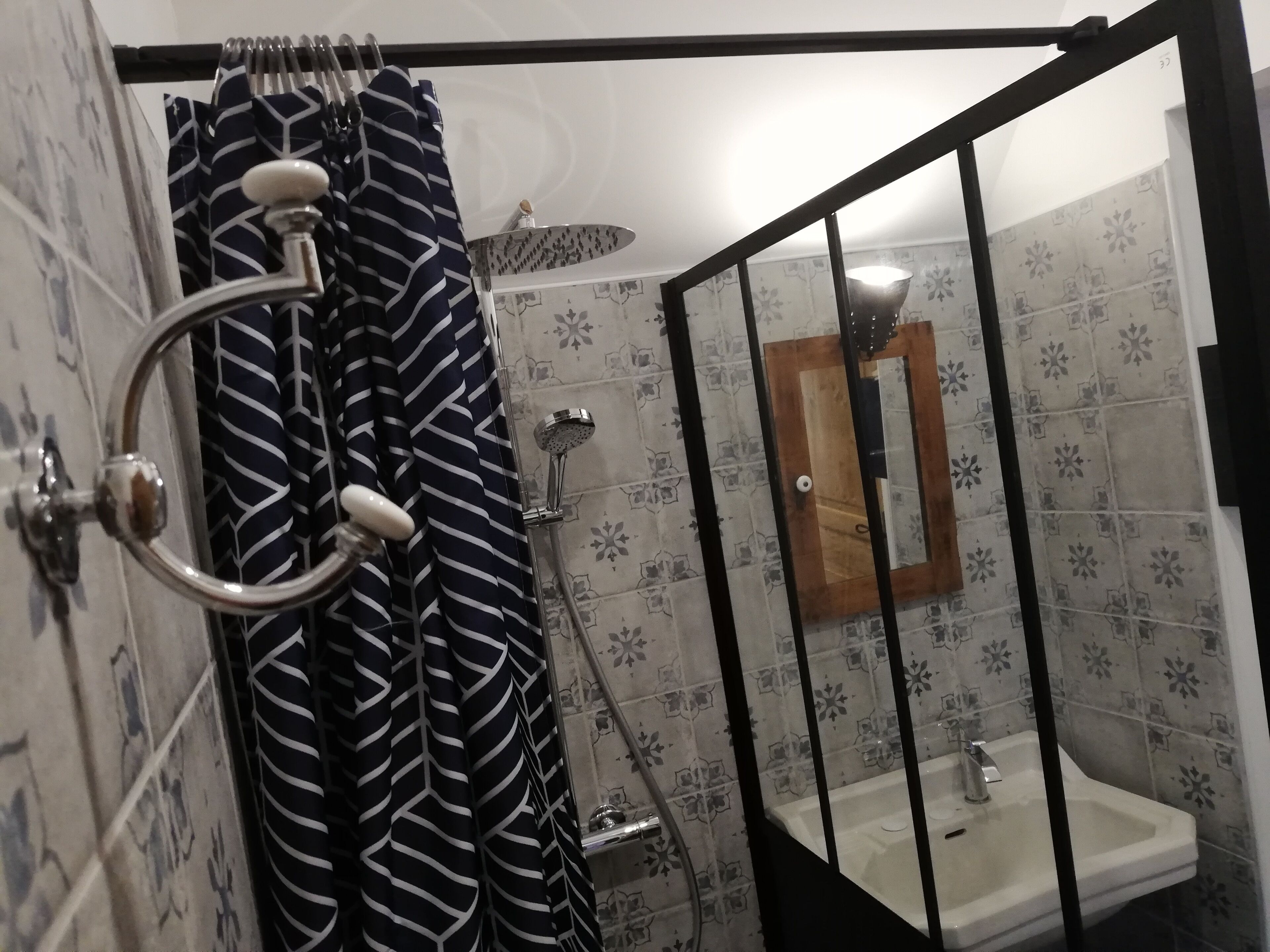 A bathroom with a shower, a sink, and a mirror.