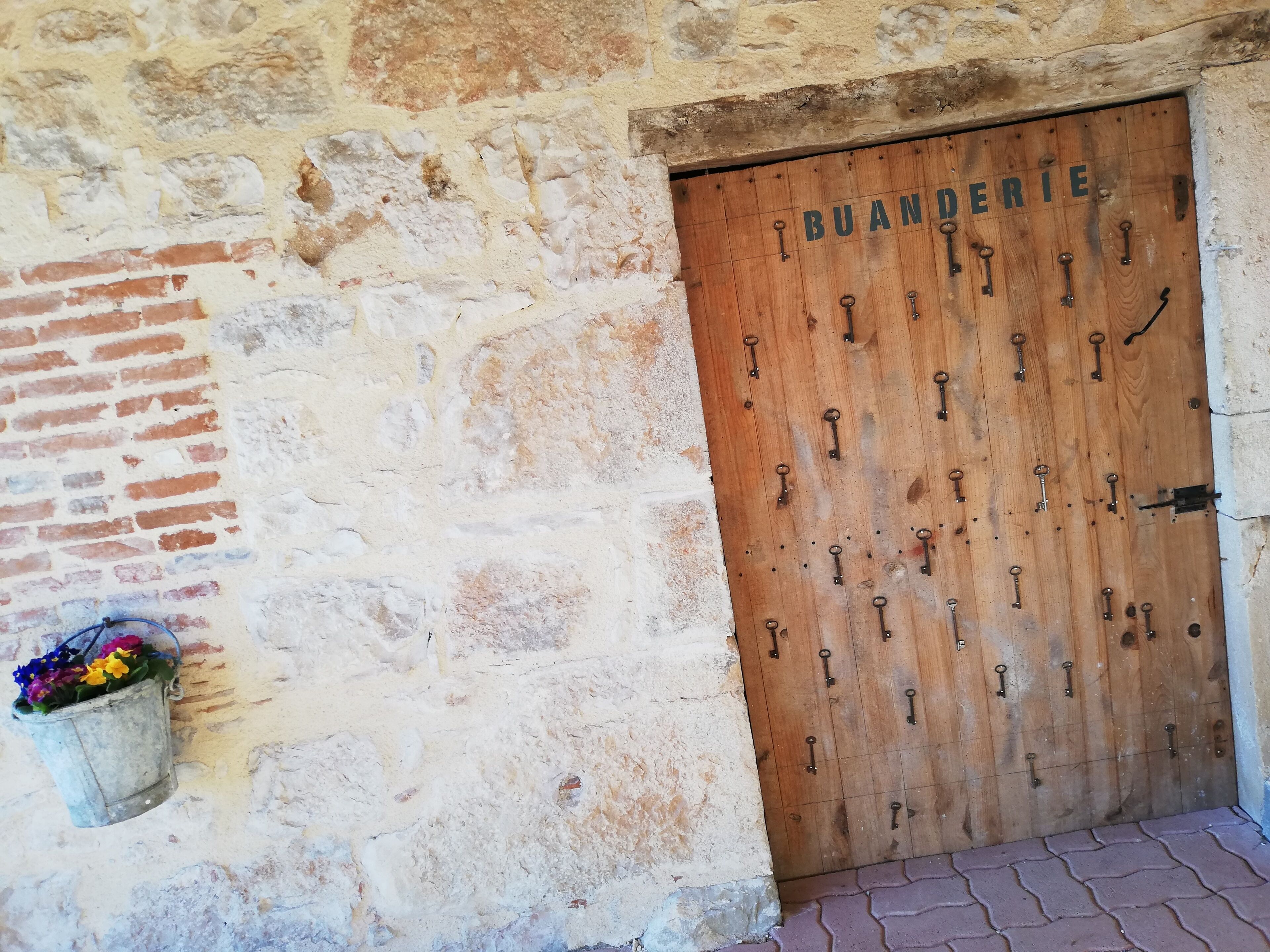 A wooden door with multiple keys hanging on it, indicating a secure entry point.