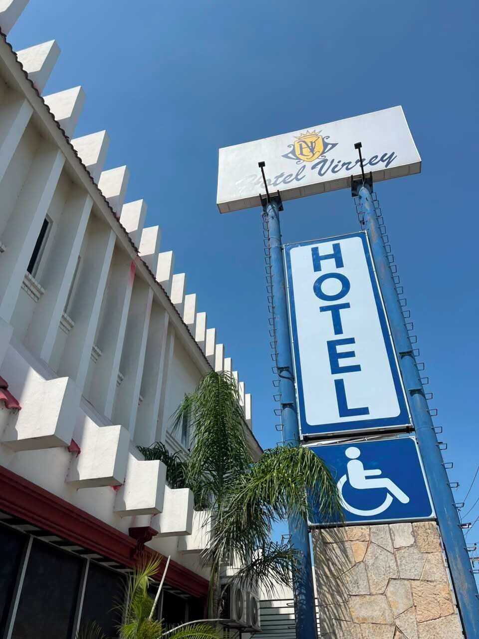 Un panneau d’hôtel portant le symbole d’accessibilité pour les personnes en fauteuil roulant, indiquant la présence d’installations accessibles.