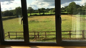 A room with large windows overlooking a grassy field and trees. - A stylish Barn conversion with the perfect mix of industrial and country styling (Bradford-on-Avon)