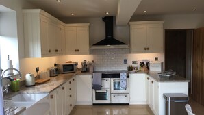 A modern kitchen with white cabinets, stainless steel appliances, and a tiled backsplash. - A stylish Barn conversion with the perfect mix of industrial and country styling (Bradford-on-Avon)