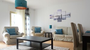 A modern living room with a sofa, two armchairs, a coffee table, and a lamp. - Entrecampos 6, luxury T3 apartment with garage. (Lisboa)