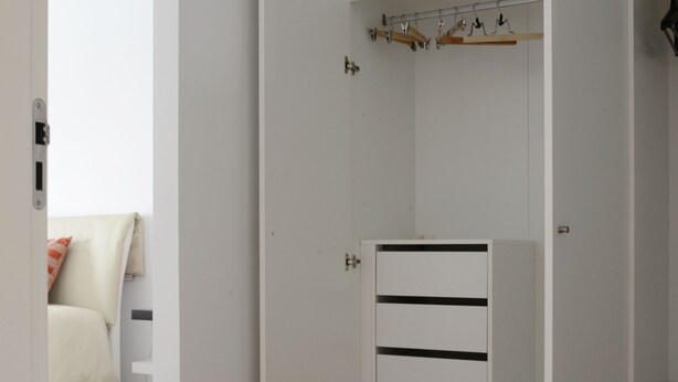 A white walk-in closet with shelves, a hanging rod, and a drawer unit. - Entrecampos 6, luxury T3 apartment with garage. (Lisboa)