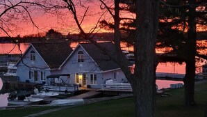 A waterfront property with two houses, a dock, and a boat.