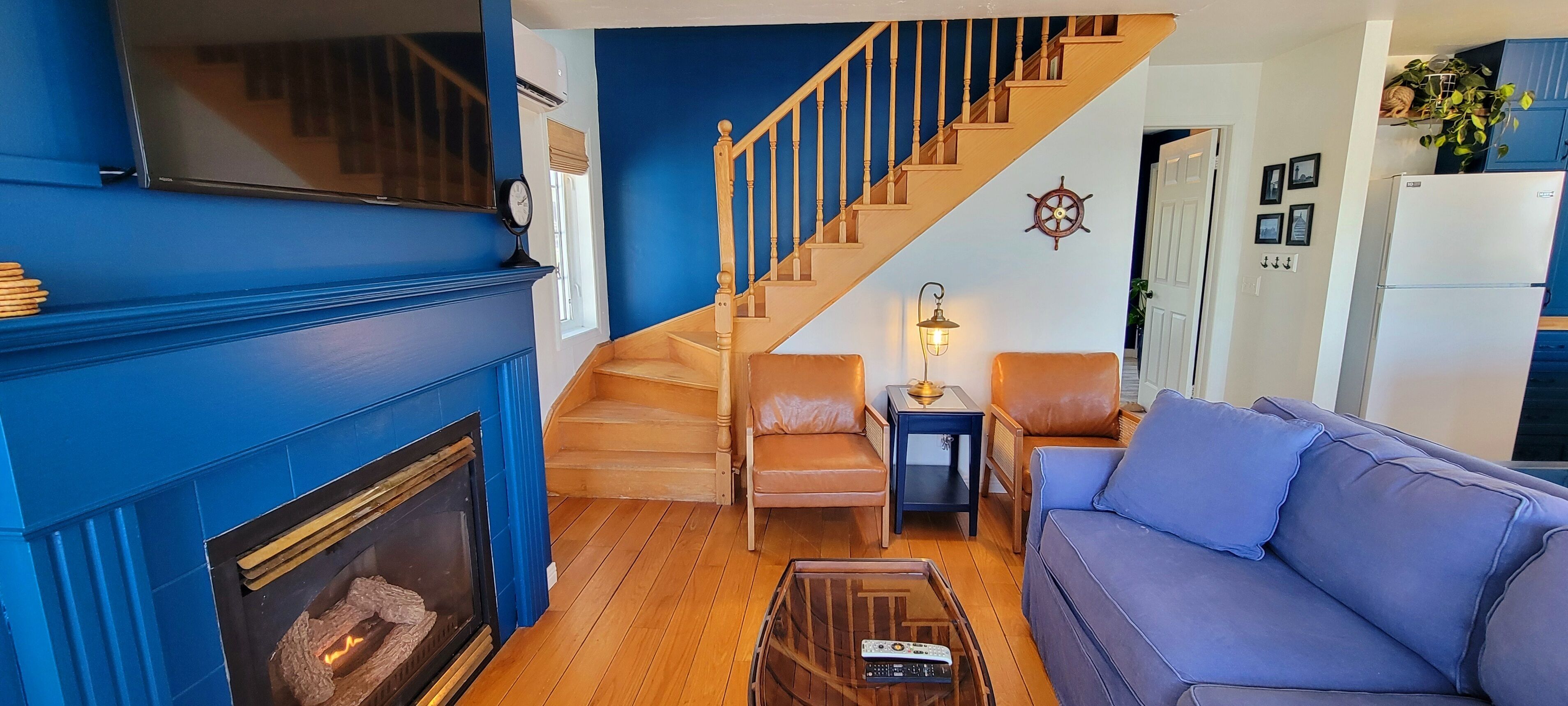 A living room with a fireplace, a staircase, a sofa, and a coffee table.