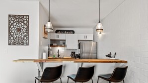 A modern kitchen with a wooden island, three black bar stools, and a stainless steel refrigerator. - ⭐️ Ski Run Steps Away, 2 Hot Tubs, Private Deck (Steamboat Springs)