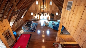 A spacious loft with a pool table, a blue sofa, and a wooden ceiling. - Rustic meets industrial: pet-friendly barn with  near Nashville, Indiana! (Nashville)