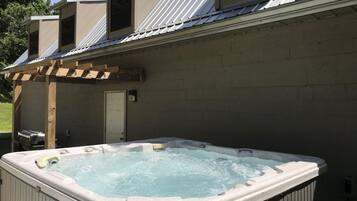 A hot tub in a covered outdoor area with a pergola structure.