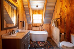 Un intérieur en bois avec une baignoire, un lavabo et des toilettes.