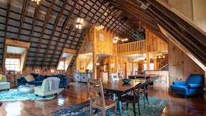 A spacious loft with high ceilings, wooden beams, a dining area, and a kitchen. - Rustic meets industrial: pet-friendly barn with  near Nashville, Indiana! (Nashville)