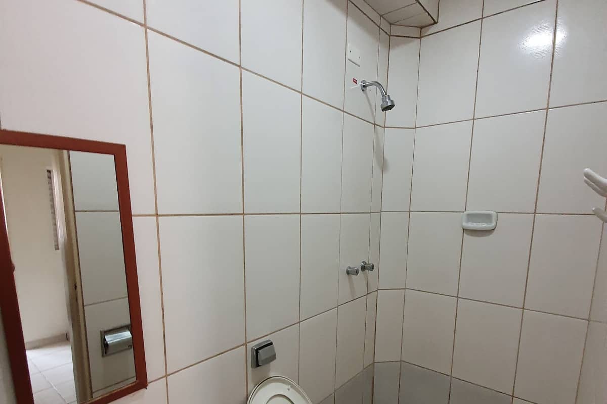 A bathroom with a sink, toilet, and mirror.