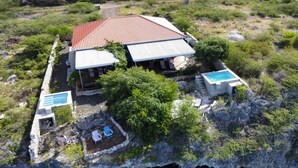 A house with a red roof, two swimming pools, and a cliffside location. - Sol Patch at Jeremi #2: a seaside guest house overlooking the Caribbean. (Willemstad)