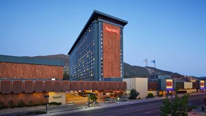 Ett Harrah's-hotell med ett markant torn, en parkeringsplats och en bergig bakgrund.