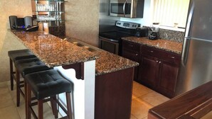A kitchen with granite countertops, stainless steel appliances, and dark wood cabinets. - Charming 2-bedroom townhome in Incline Village close to mountain and restaurants (incline village)