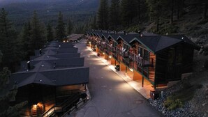 A row of log cabin-style lodges with a central walkway, surrounded by forested mountains. - Charming 2-bedroom townhome in Incline Village close to mountain and restaurants (incline village)