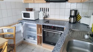 Una cocina compacta equipada con microondas, cafetera, tostadora y horno integrado.