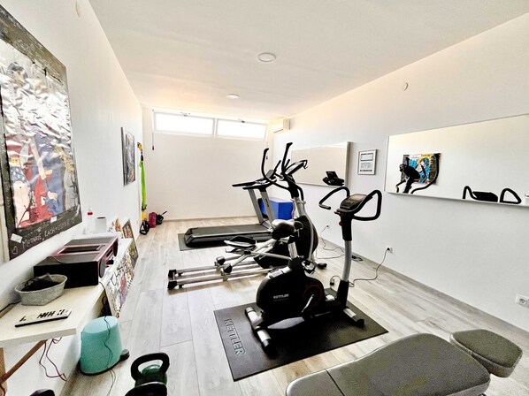 A home gym with exercise equipment, a yoga mat, and a kettlebell.