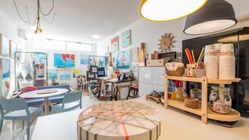 Une cuisine moderne et bien éclairée, avec une table de salle à manger ronde, des chaises, ainsi qu’une variété d’appareils de cuisine et d’ustensiles.