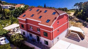 Un edificio de dos pisos con techo rojo y paredes blancas, situado cerca de una masa de agua.