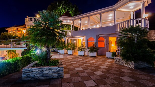 Una casa grande y moderna con un amplio espacio exterior, piscina y jardines bien cuidados.