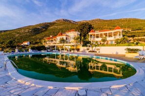 En swimmingpool med liggestole og en bygning med flere balkoner.