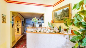 Eine Hotelhalle mit Empfangstresen, einer Treppe und einem Essbereich.