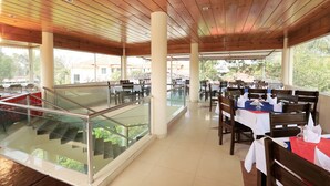 A spacious restaurant with wooden ceiling, glass railings, and outdoor seating. - La Bella Resort (Cox's Bazar)