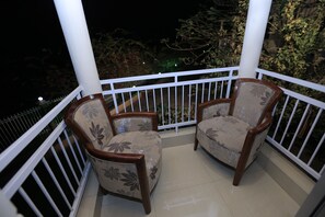 A balcony with two chairs and a white railing. - La Bella Resort (Cox's Bazar)