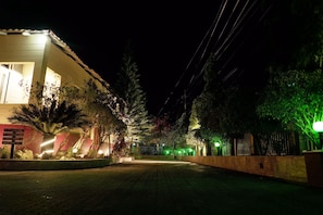 A nighttime view of a building with illuminated windows and a paved area in front. - La Bella Resort (Cox's Bazar)