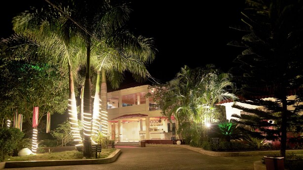 A hotel entrance at night with illuminated trees and a well-lit building facade. - La Bella Resort (Cox's Bazar)