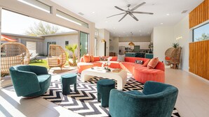 Een moderne woonkamer met een bank, stoelen en een salontafel.