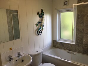 Une salle de bain avec un lavabo, des toilettes et une baignoire.