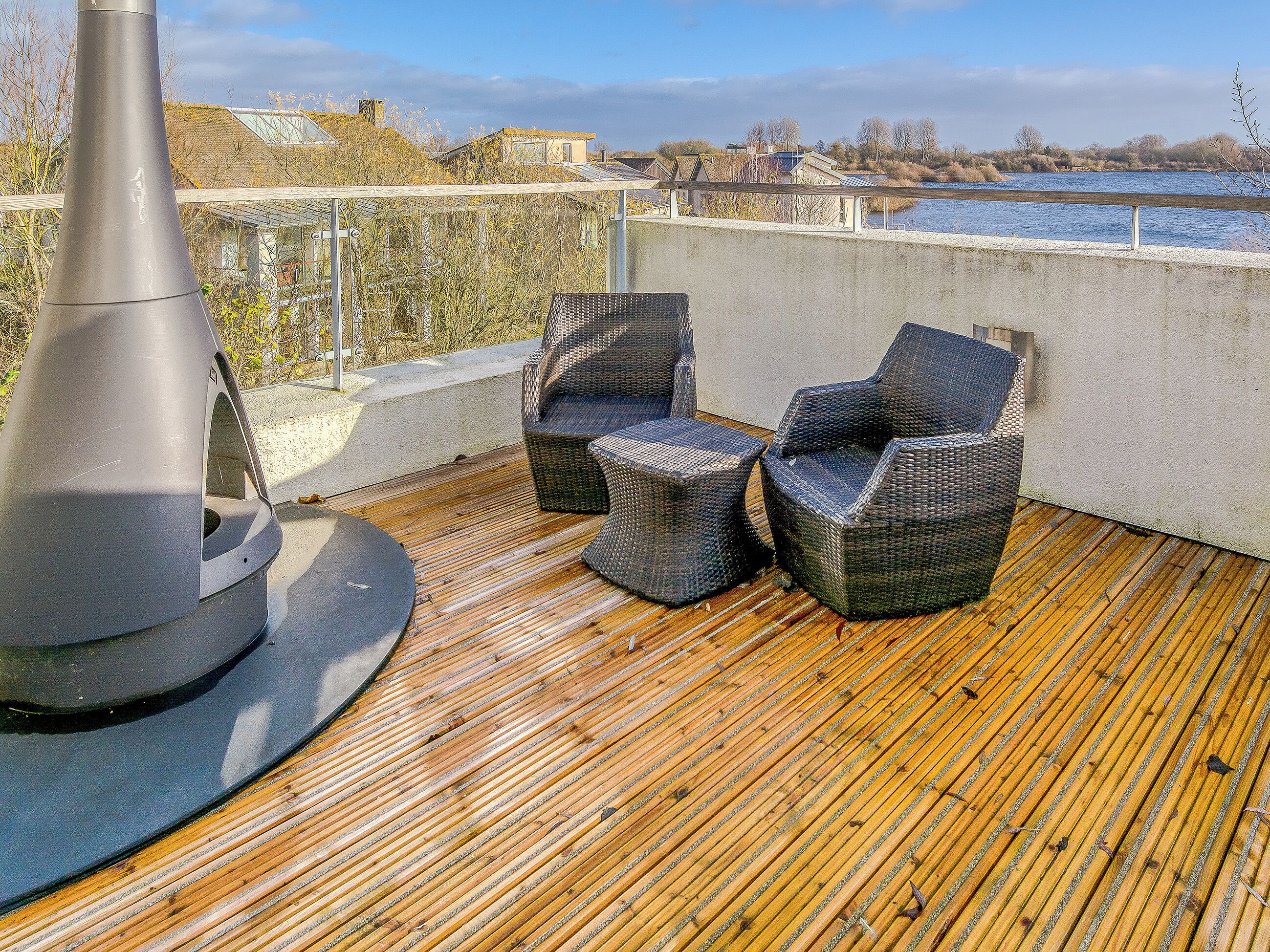 A deck with wicker furniture and a grill.