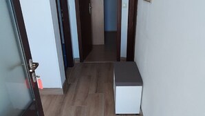 A hallway with a wooden bench, a door, and a wall-mounted plaque. - Apartment Classic Korčula - Two Bedroom Apartment with Terrace and Sea View (Korcula)