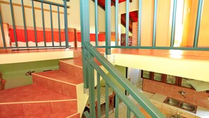 Un interior con varios niveles, una escalera, una zona de cocina y un espacio para comer.