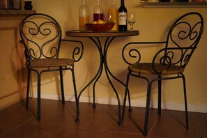 Un coin repas avec deux chaises en métal et une petite table ronde.