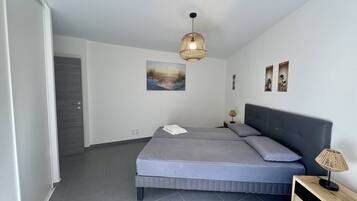 Ein modernes Schlafzimmer mit einem Bett, einer Nachttischlampe und einem Bild an der Wand.