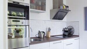 Eine moderne Küche mit Edelstahlgeräten, einer Kaffeemaschine und einem Messerblock.