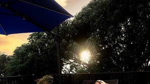 A woman reclining on a lounge chair with a drink, surrounded by greenery and a sunset. - Villa Xona - a Luxury villa with stunning views - perfect for entertaining (Castries)