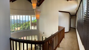 A high-ceilinged interior with a curved balcony overlooking a scenic landscape. - Villa Xona - a Luxury villa with stunning views - perfect for entertaining (Castries)