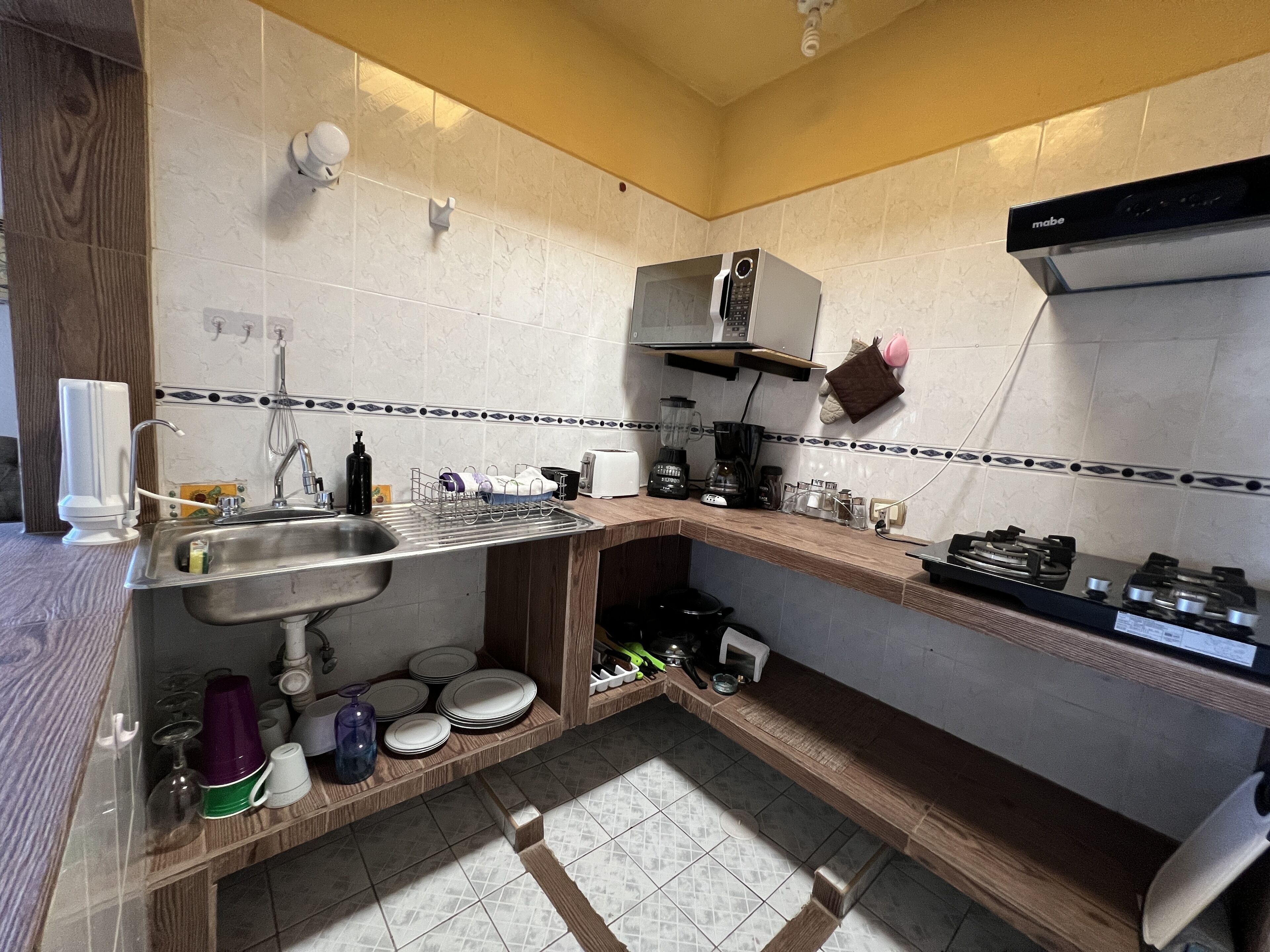 A compact kitchen with a sink, stove, and various appliances.