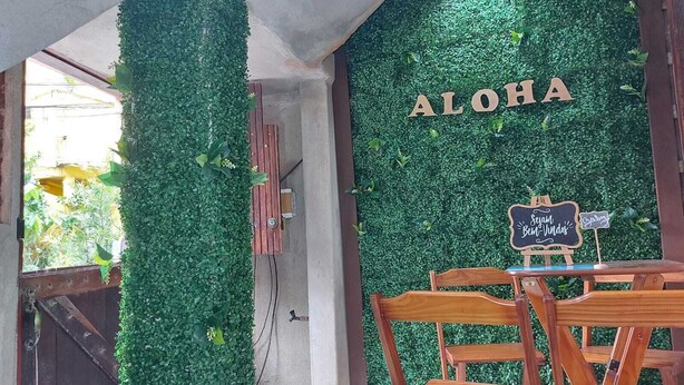 Interior de restaurante con una pared verde y sillas de madera.