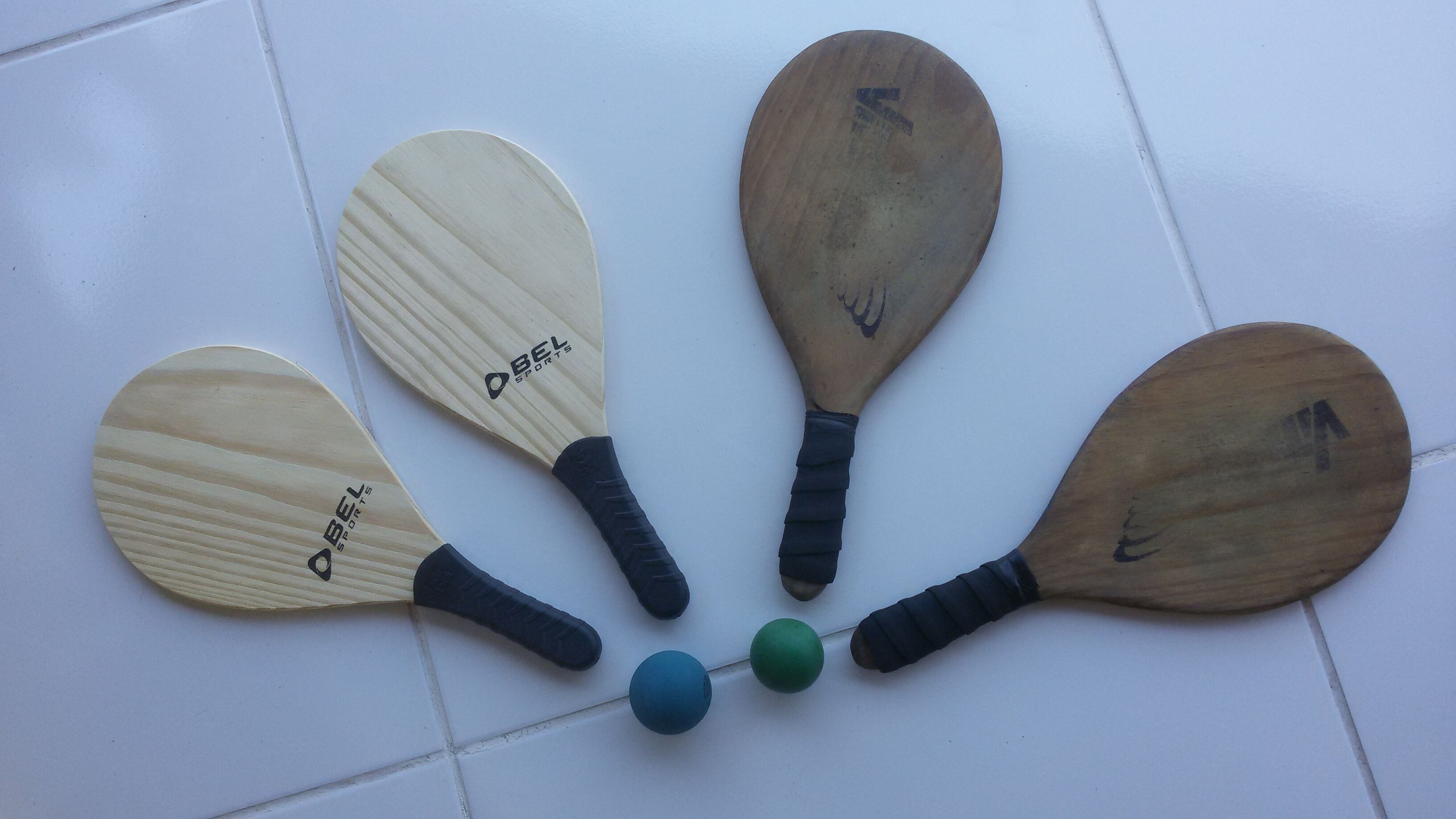 Cinco tablas de paddleboard con la marca "BEL SPORTS" sobre un suelo de baldosas.