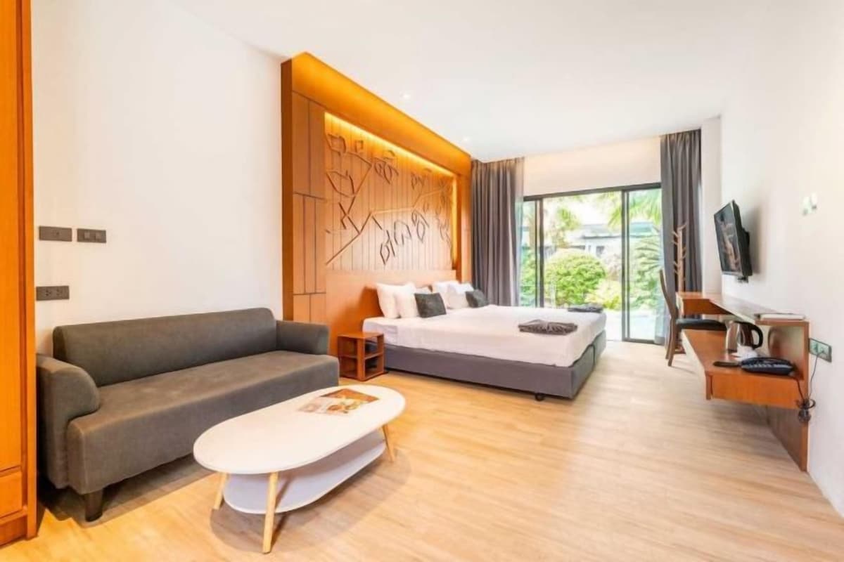 Une chambre d’hôtel moderne équipée d’un canapé, d’un lit, d’une télévision et d’un bureau.