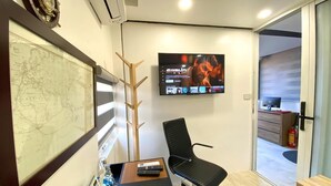 A modern office with a desk, chair, mounted TV, and a large map on the wall. - Banana Inn Hostel (Hanoi)